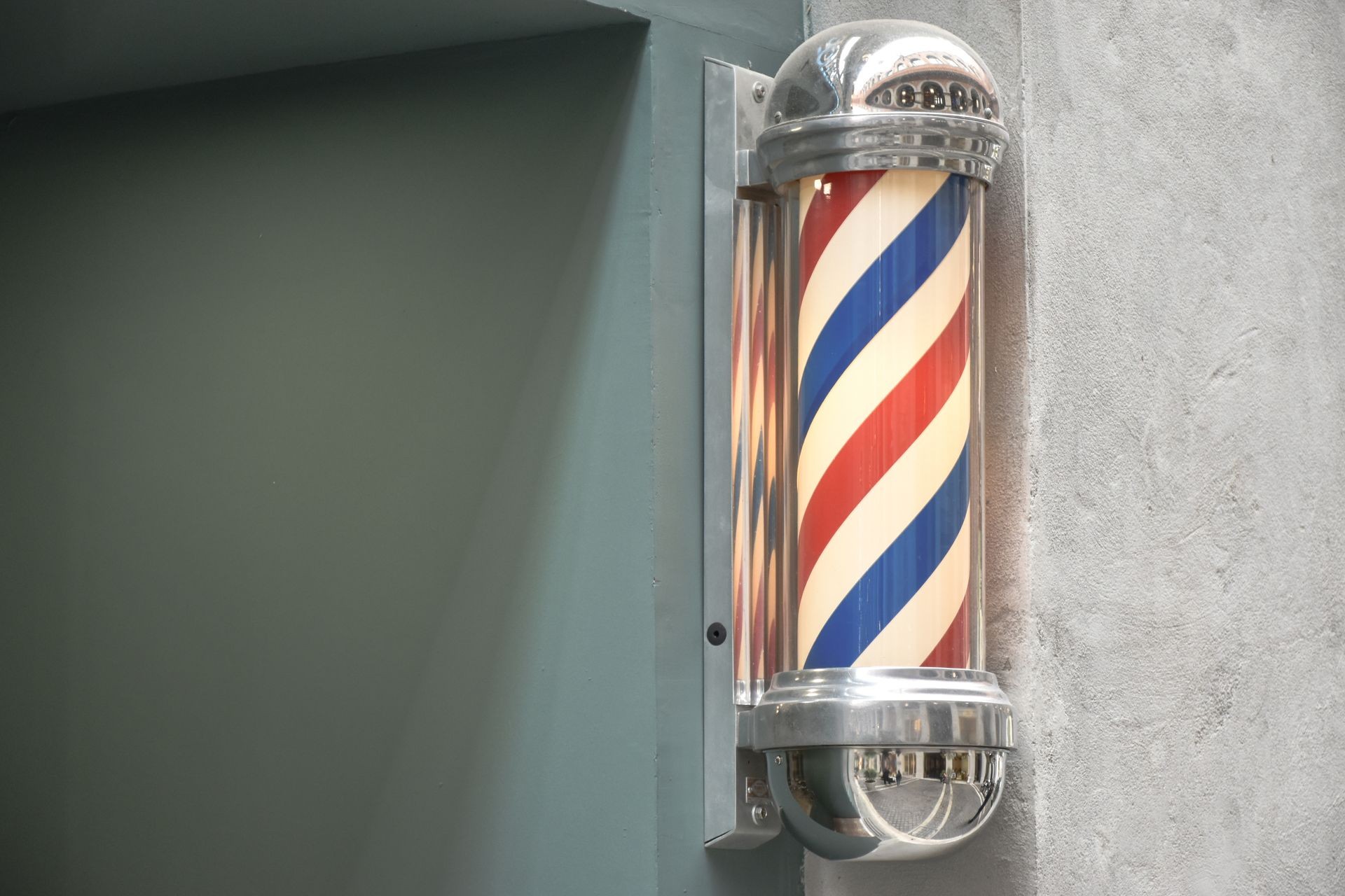 Close up to barbershop pole on wall background view. Copy space.